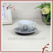 Ceramic white cup and saucer with decal on it
